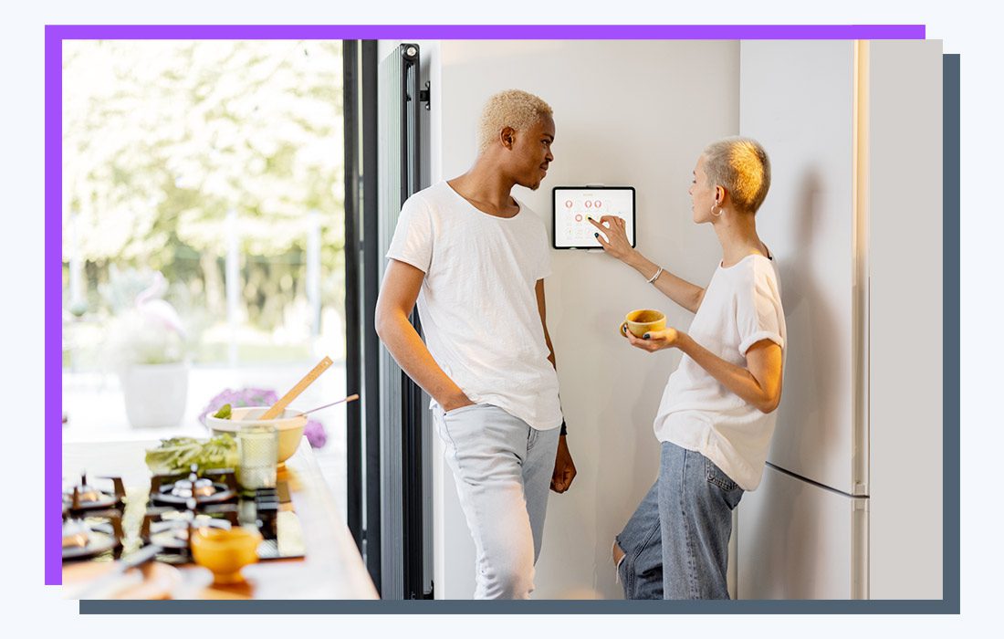 two people in white shirts standing beside a wall-mounted smart home lighting system.
