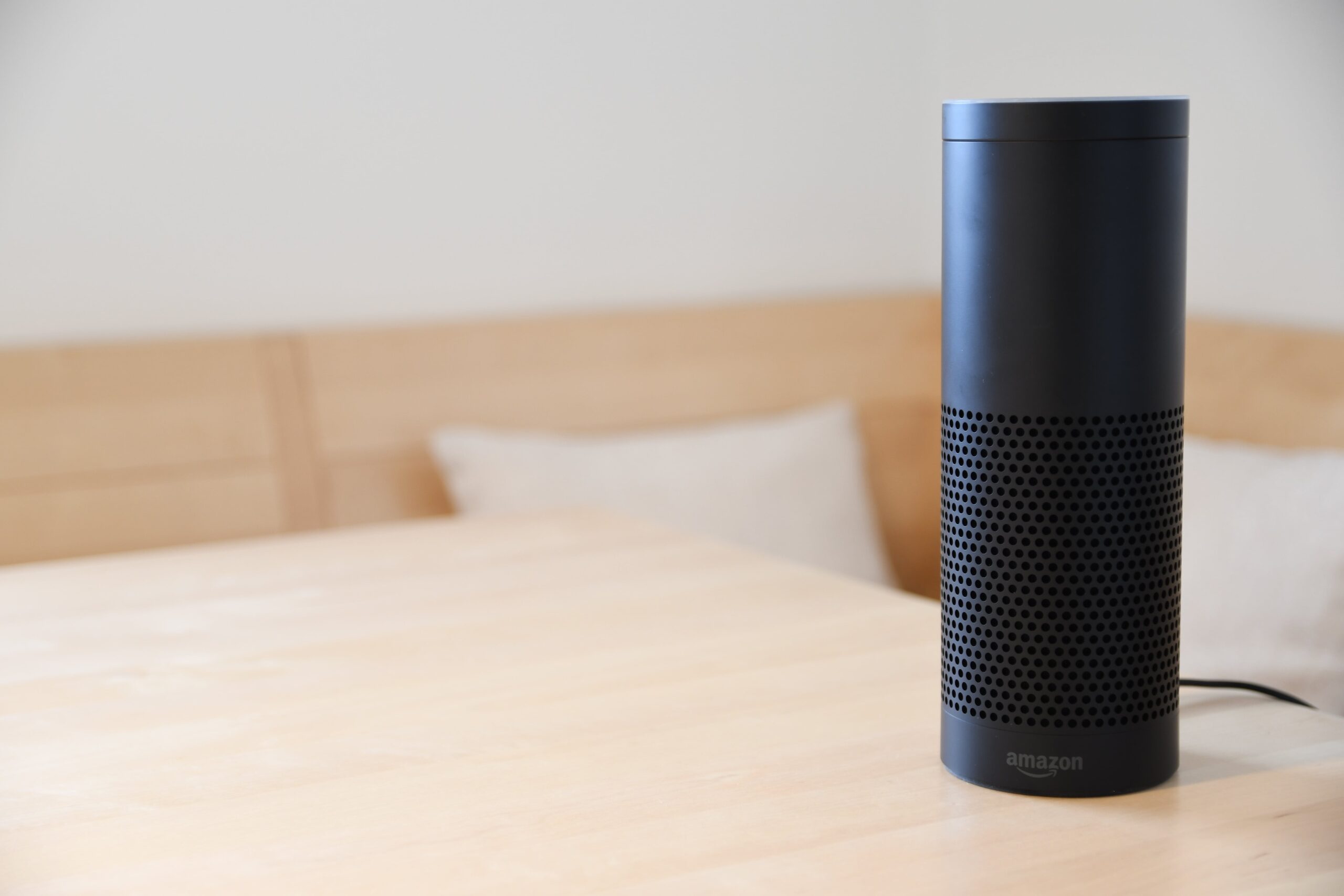 An Amazon Echo smart home device on a wood surface.