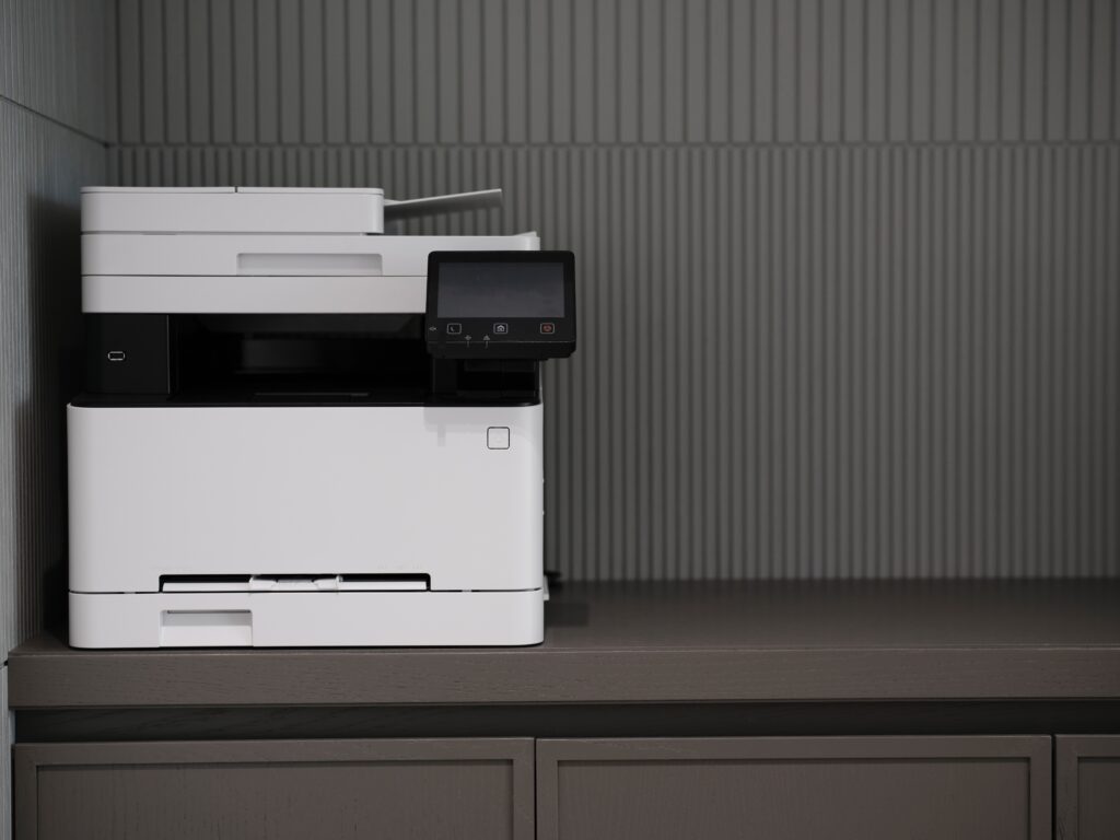 a white and black printer sitting on top of a gray counter.