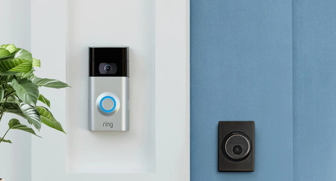 Ring Video Doorbell 2 mounted beside a blue front door with the blue LED light on before disabling the device without the app.