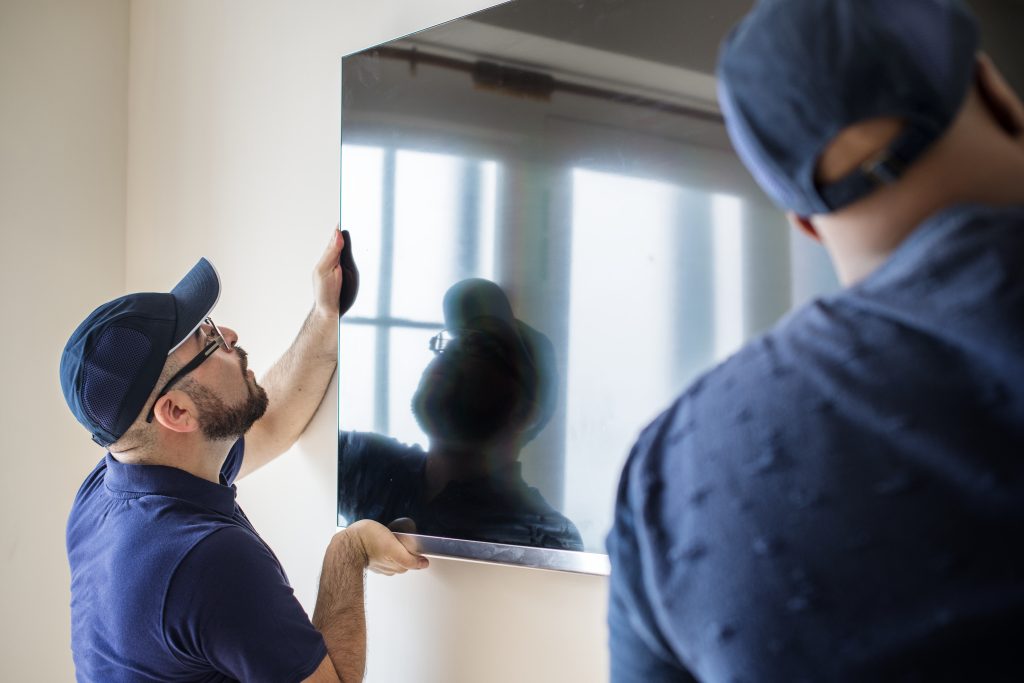 two technicians determining the best sport for a mounted tv