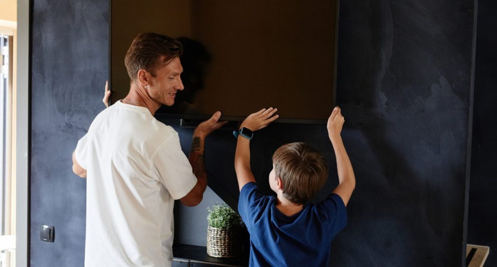 Two people learning how to mount TV on wall safely